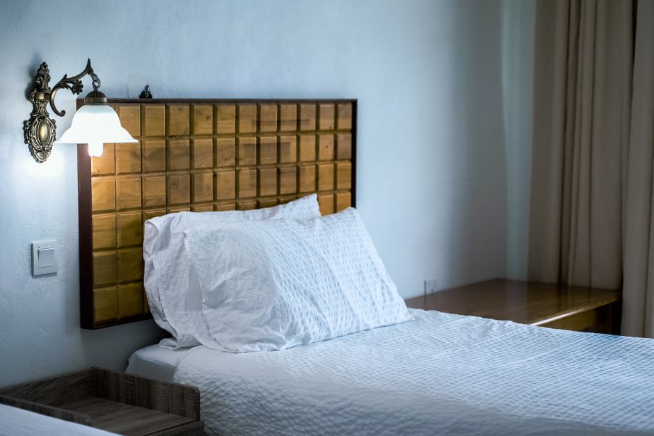 Cama Cancún tamaño king con cabecera tapizada en bouclé